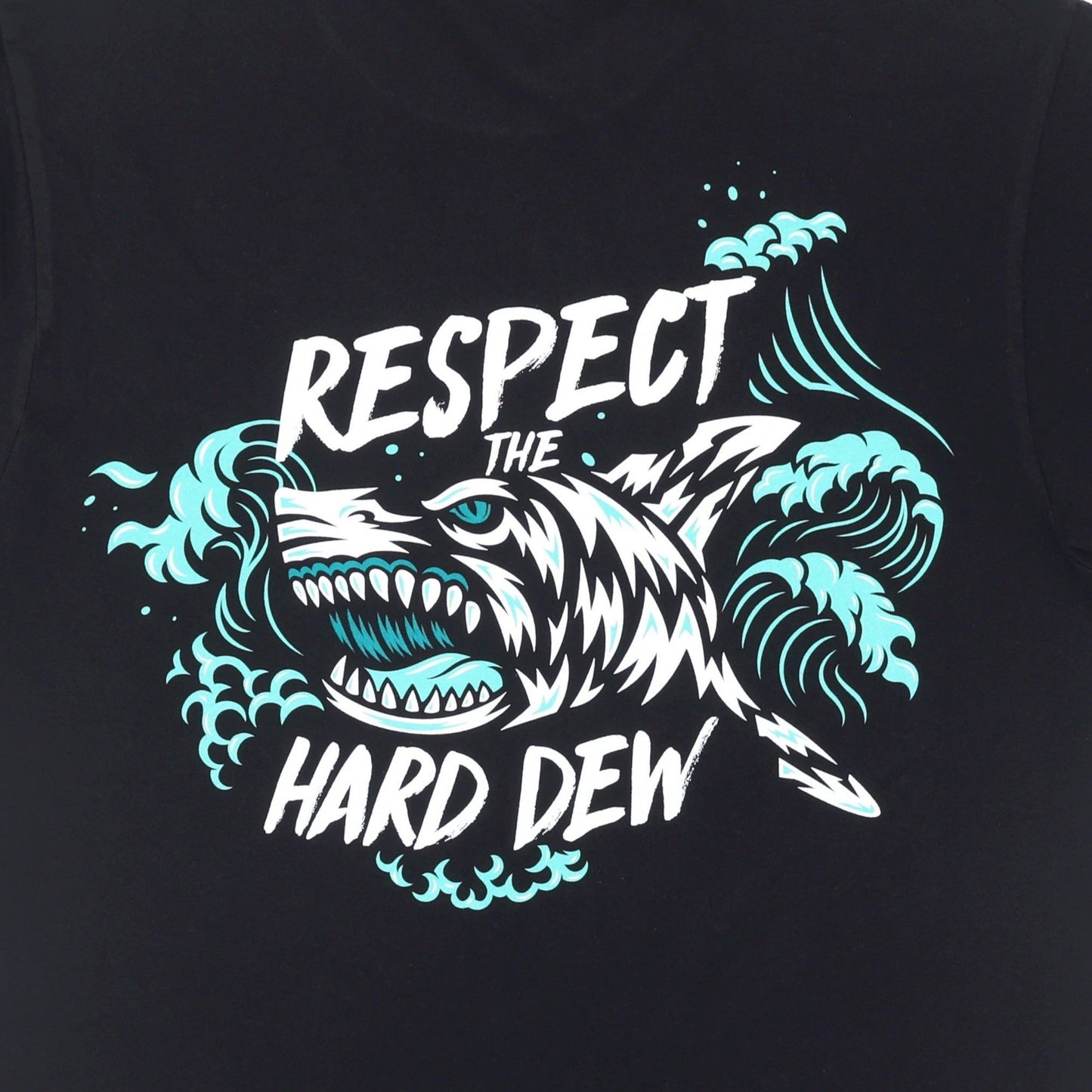 Close-up of the back design on the black Hard Mountain Dew tee shirt, featuring the teal, white, and black shark emerging from crashing waves, with the stylized text 'Respect the Hard Dew' around the shark illustration.