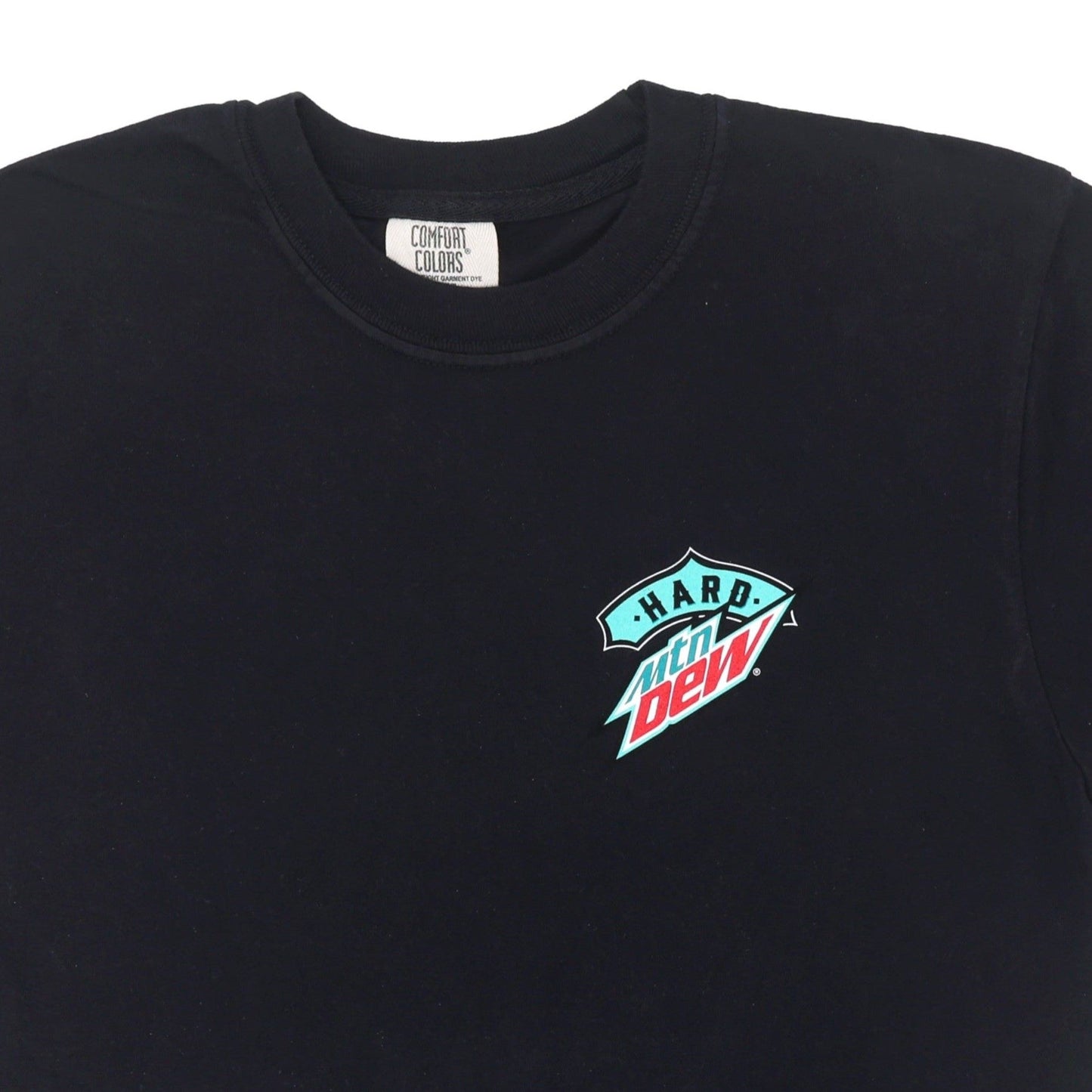 Close-up of the front logo on the black Hard Mountain Dew tee shirt, showing the small teal, white, and red logo on the left chest pocket area.