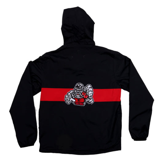 The reverse side of a black hooded windbreaker laid flat. A wide horizontal red stripe extends across the middle of the back. Centered on this red stripe is a graphic of a white and grey gorilla with red eyes and a fierce expression, holding cherries.