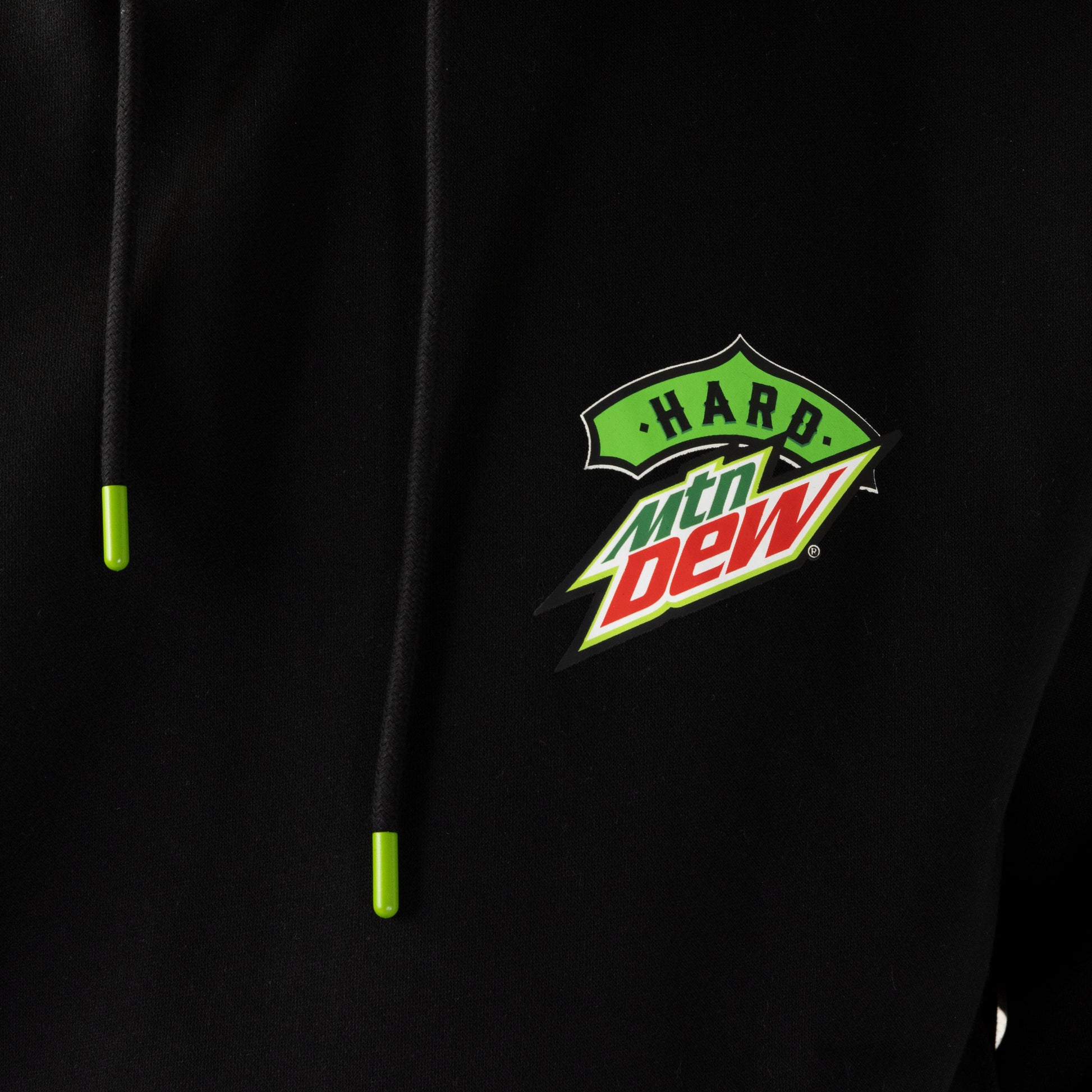 Close-up image of the black Hard Mountain Dew hoodie, showing the small logo on the left chest and the bright neon green drawstring tips.