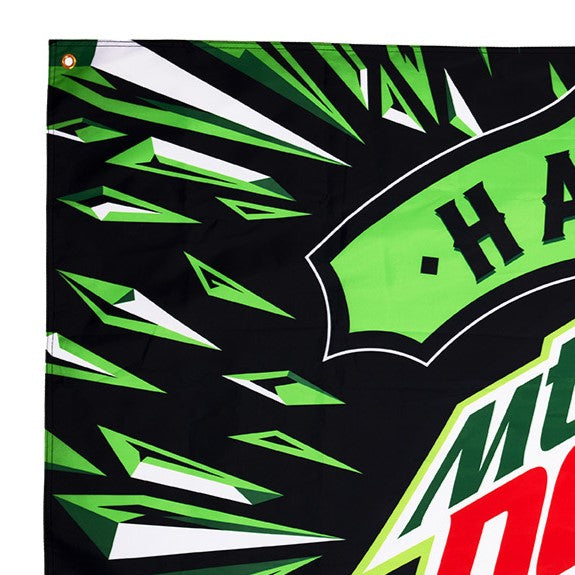 Flat lay of a large Hard Mountain Dew flag featuring a bright green glass shard design with the large Hard Mountain Dew logo prominently displayed in the center. The flag's design showcases bold, vibrant graphics against a striking background.