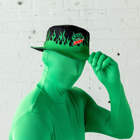 Model wearing a bucket hat with the flame design side facing outward. The hat features a black and green flame pattern, with the Hard Mountain Dew logo visible.