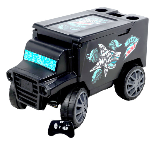 Remote control cooler shaped like an armored truck. The cooler is black with grey hubcaps. The front window features a teal and light teal water pattern. The side displays a teal and white shark and wave design next to the Hard Mountain Dew logo. The image also includes the controller used to drive the remote control cooler.